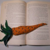A book weight shaped like a carrot, holding open a book.
