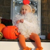 A toddler in a fluffy chicken costume for Halloween.