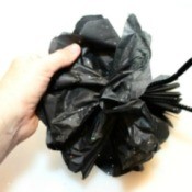 A decorative flower made out of black tissue paper.