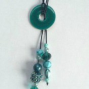 A lariat necklace with a decorated washer in the middle.