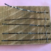 A thumb piano made from bobby pins stapled to a piece of wood.