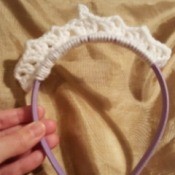 A crocheted headband in the shape of a tiara.